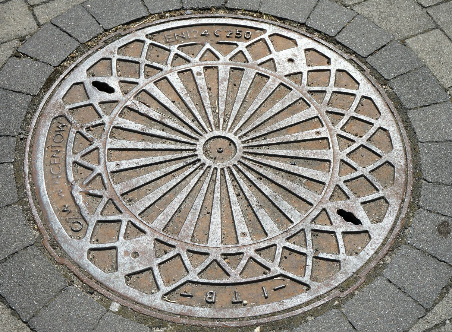 Manhole cover undergoing load and durability testing in laboratory conditions